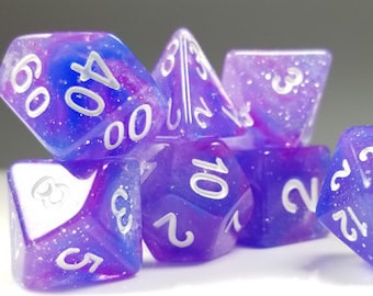 May include: A set of seven purple and blue dice with white numbers. The dice are made of a translucent material with a glittery finish.