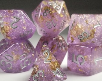 May include: A set of six purple dice with gold flecks and silver numbers. The dice are a d4, d6, d8, d10, d12, and d20.