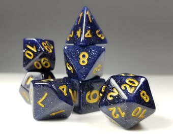 May include: A set of six blue and gold dice with a speckled finish. The dice are in various positions, with one die stacked on top of another.