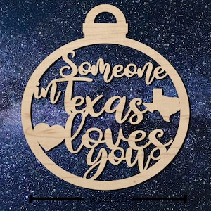 May include: Wooden Christmas ornament shaped like a circle with the text "Someone in Texas loves you" and a heart and outline of the state of Texas.