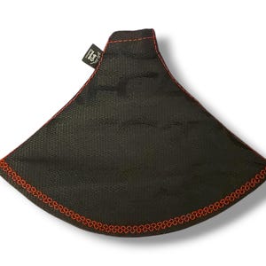 以下が含まれることがあります： 赤いステッチの縁取りが施された黒い布製のコーヒーフィルター。フィルターには、白い文字で「Hario」と書かれた小さな黒いラベルが付いています。