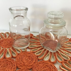 Puede incluir: Una taza de cerámica blanca con un asa negra y el texto "But First, Coffee" en negro, con una fuente de estilo manuscrito. La taza está sobre una superficie blanca.