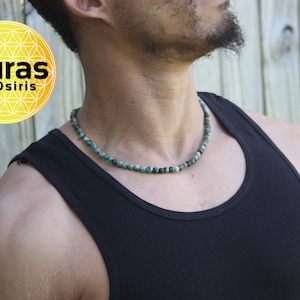 May include: A turquoise beaded necklace on a person wearing a black tank top. The necklace is made of small, round beads and is about 18 inches long.
