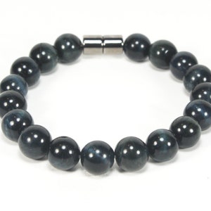 May include: A dark blue beaded bracelet with a magnetic clasp. The beads are round and have a subtle shimmer.