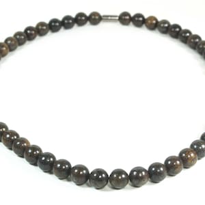 May include: A brown beaded necklace with a magnetic clasp.