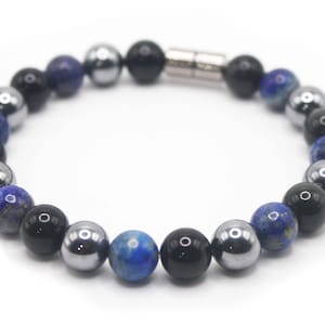 May include: A beaded bracelet with blue, black and silver beads. The bracelet has a magnetic clasp.