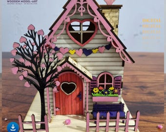 Puede incluir: Un modelo de madera rosa y blanco de una casa con una puerta y ventanas en forma de corazón. La casa tiene una valla y un árbol con hojas en forma de corazones rosas. Las palabras "Love" y "Digital" son visibles en la imagen.