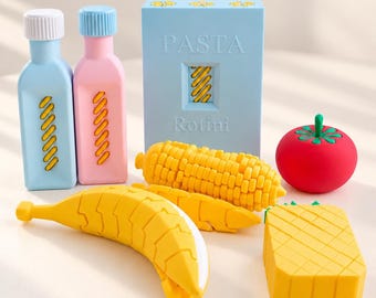 May include: A collection of food-themed items including a light blue bottle, a pink bottle, a light blue box labeled PASTA Rotini, a yellow corn cob, a red tomato, a yellow banana, and a yellow pineapple, all featuring a textured, blocky design.