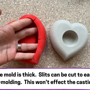 May include: Two heart-shaped silicone molds, one red and one gray. The red mold has slits cut into the side to make it easier to remove the finished product. The gray mold has a circular indentation in the center. The text "HDC" is printed on the gray mold.