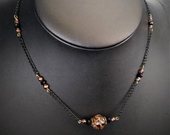 Unique artisanal glass bead necklace with black copper and gold inclusions on black metal chain and faceted beads - women's jewelry gift idea