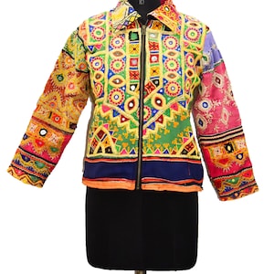 Könnte beinhalten: Eine farbenfrohe Jacke mit Reißverschluss, die mit aufwendigen Stickereien und Spiegelarbeiten verziert ist. Die Jacke besteht aus einem Patchwork aus verschiedenen Stoffen und hat einen lebendigen, bohemischen Stil.