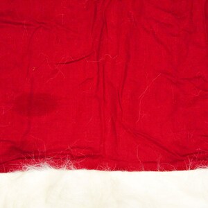 May include: A red Santa hat with a white fur trim. The hat is made of felt and has a classic Santa hat shape.