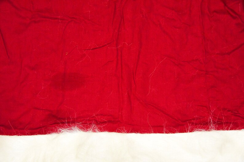 May include: A red Santa hat with a white fur trim. The hat is made of felt and has a classic Santa hat shape.
