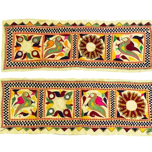 May include: Two embroidered fabric panels with a repeating pattern of colorful birds, flowers, and mirrors. The panels are cream colored with a black, red, and yellow border.
