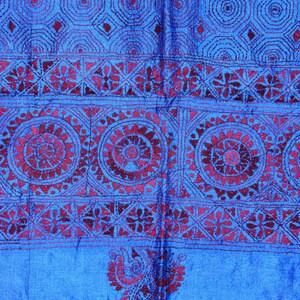 May include: A blue fabric with a red embroidered design. The design features intricate patterns of circles, flowers, and geometric shapes.