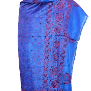 May include: A blue silk scarf with a red and white geometric pattern. The scarf is folded and draped over a mannequin.