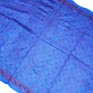 May include: A blue fabric with a red and blue patterned design. The fabric has a geometric pattern of circles and diamonds.