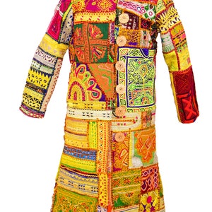 Könnte beinhalten: Ein langer Patchwork-Mantel mit einer lebendigen Mischung aus Farben wie Gelb, Rosa, Grün und Orange. Der Mantel weist aufwendige Stickmuster und große Holzknöpfe auf. Der Mantel wird auf einer Schaufensterpuppe präsentiert.