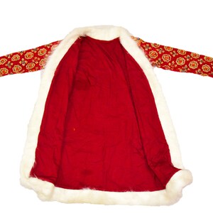 May include: A red coat with a white fur trim and a floral pattern on the sleeves. The coat is unbuttoned and the lining is visible.