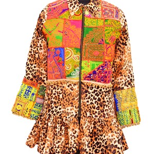 Puede incluir: Una chaqueta vibrante con un diseño de patchwork y un estampado de leopardo. La chaqueta tiene cierre de cremallera, dobladillo con volantes y detalles bordados coloridos. Las mangas y el cuello tienen estampado de leopardo.