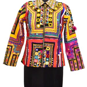 May include: A vibrant, multi-colored jacket with intricate embroidery and mirror accents. The jacket features a black zipper, a collar, and long sleeves. The design incorporates red, yellow, blue, and pink hues, creating a patchwork effect. The jacket is displayed on a mannequin.
