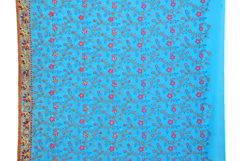 May include: A blue fabric with a floral pattern embroidered in pink, gold, and silver thread. The fabric has a gold and silver border.