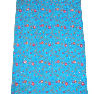 May include: A turquoise blue fabric with a floral pattern. The fabric has a gold and red trim with sequins and beads.
