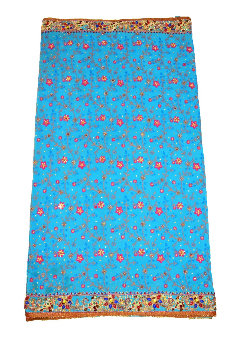 May include: A turquoise blue fabric with a floral pattern. The fabric has a gold and red trim with sequins and beads.