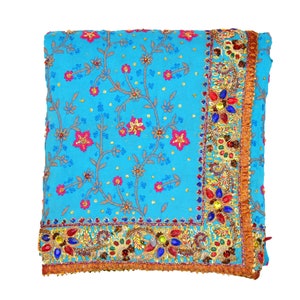 May include: A blue and gold embroidered sari with a floral pattern and jeweled trim.