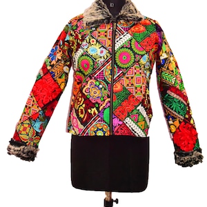 以下が含まれることがあります： フェイクファーの襟とカフスが付いたカラフルなパッチワークジャケット。ジャケットは異なる生地で作られており、複雑な刺繍のディテールが施されています。