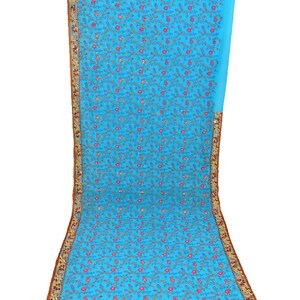 May include: A light blue chiffon saree with a floral embroidery pattern. The saree has a gold and brown border with intricate details.