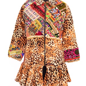 Könnte beinhalten: Eine braune und schwarze Jacke im Leopardenmuster mit einem bunten Patchwork-Design auf der Vorderseite und einem Reißverschluss. Die Jacke hat einen Rüschen-Saum und einen Perlenbesatz.