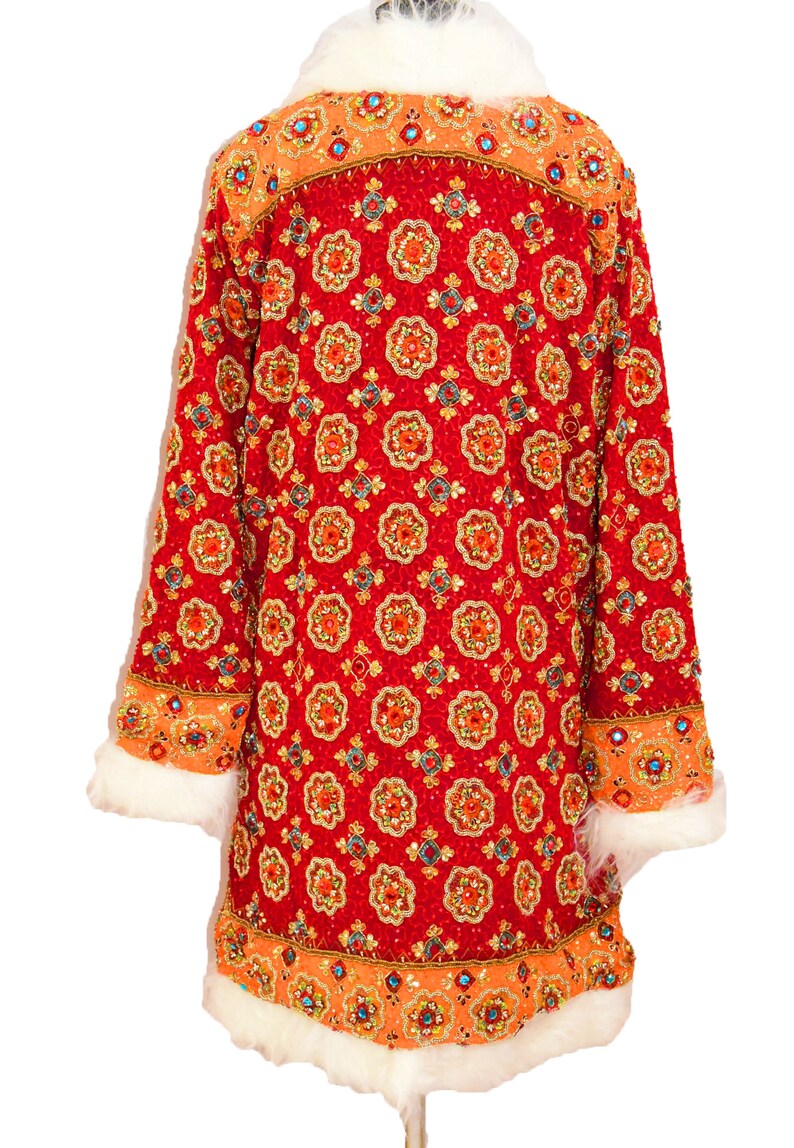 May include: A red sequined jacket with a white fur collar and cuffs. The jacket is covered in a repeating pattern of orange, blue, and gold sequins.