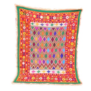 Könnte beinhalten: Ein farbenfroher handgefertigter Wandbehang aus Textilien mit einem geometrischen Diamantenmuster in den Farben Rosa, Blau, Grün, Gelb und Orange. Der Rand zeigt ein sich wiederholendes Muster aus Kreisen, Sternen und anderen Formen in Rot, Gelb und Grün.