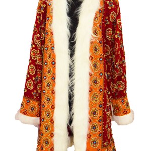 May include: A long, red and orange patterned coat with a white fur collar and cuffs. The coat is decorated with sequins and beads.