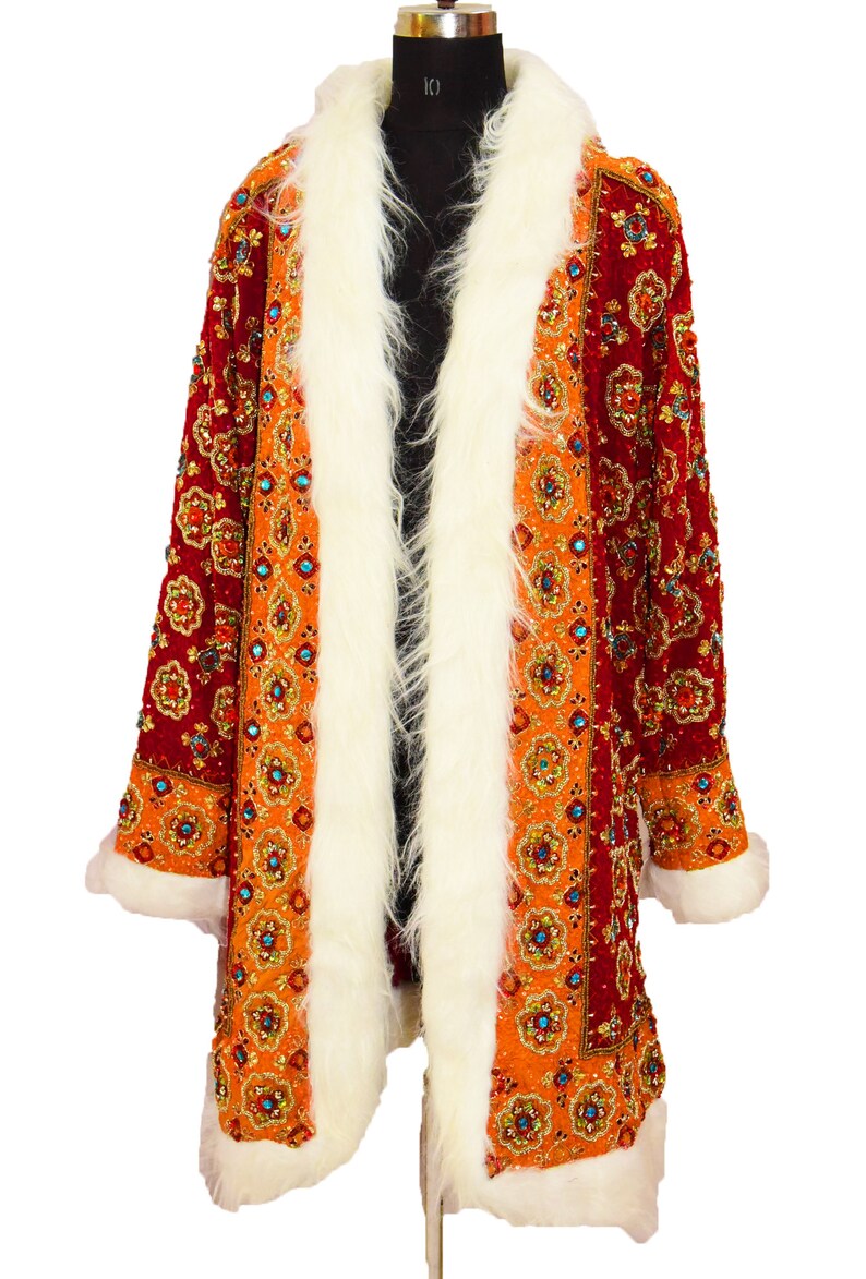May include: A long, red and orange patterned coat with a white fur collar and cuffs. The coat is decorated with sequins and beads.
