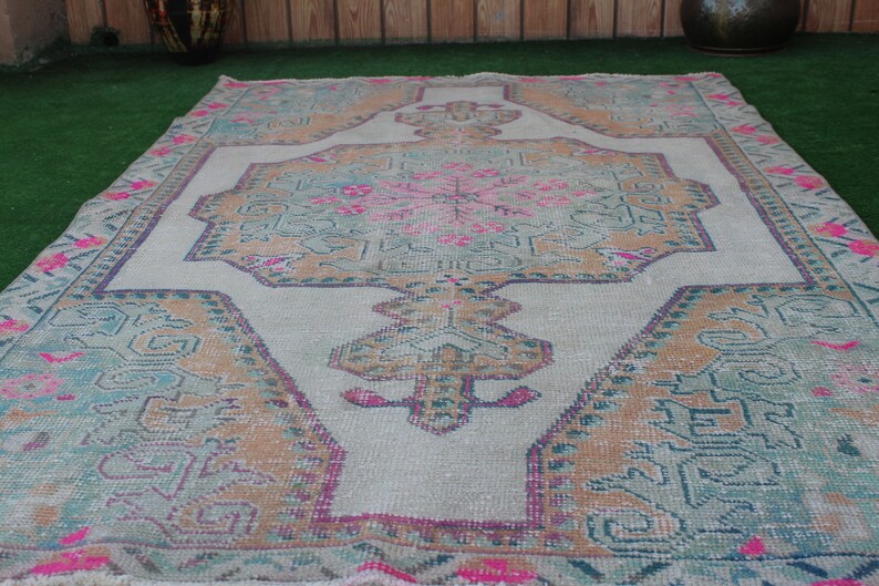 Puede incluir: Una alfombra vintage con un patr&oacute;n floral descolorido en tonos rosa, azul y marr&oacute;n. La alfombra tiene un fondo blanco y un aspecto desgastado.