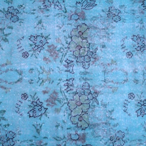 Pu&ograve; includere: Un tappeto vintage con sfondo blu e un motivo floreale in tonalit&agrave; di verde e nero.