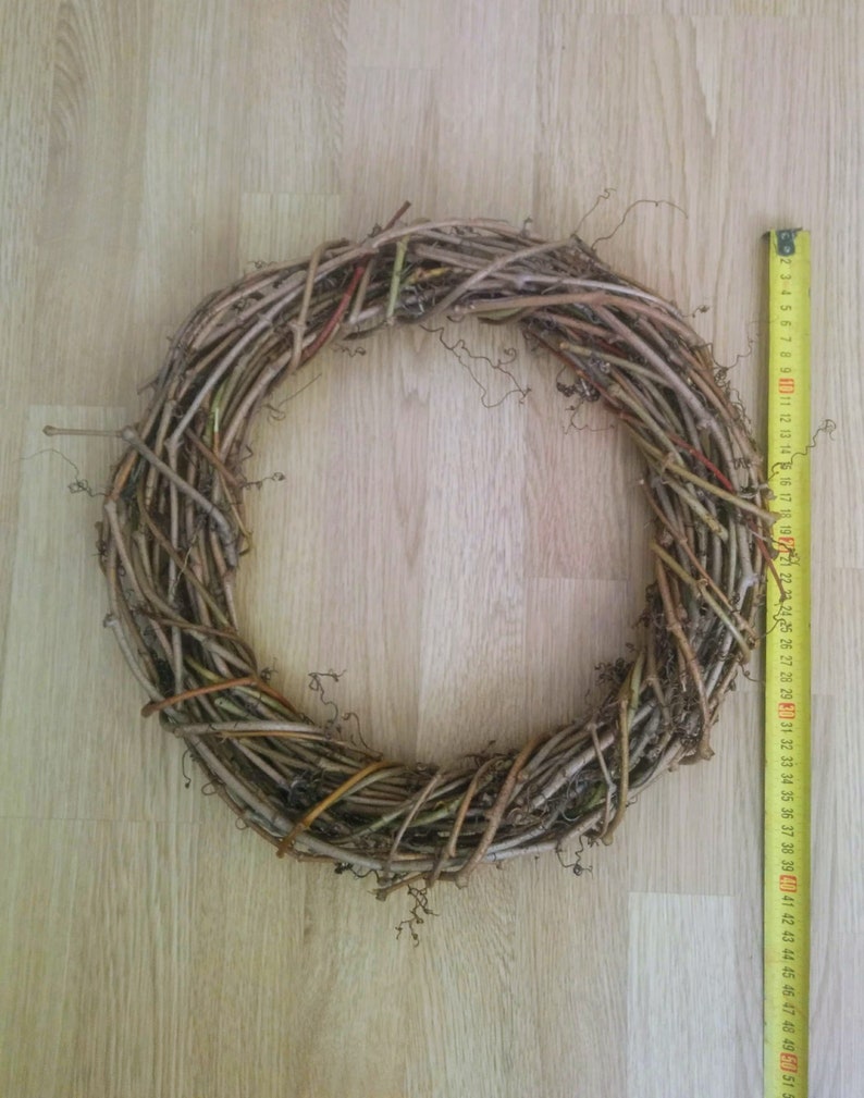 May include: A brown twig wreath with a diameter of approximately 30 cm. The wreath is made of natural twigs and is perfect for decorating for the holidays or for everyday use.
