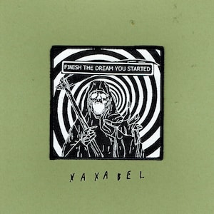 May include: Black and white patch with a Grim Reaper design, holding a scythe and set against a swirling background. The text above reads "FINISH THE DREAM YOU STARTED", with "X A X A B E L" below.