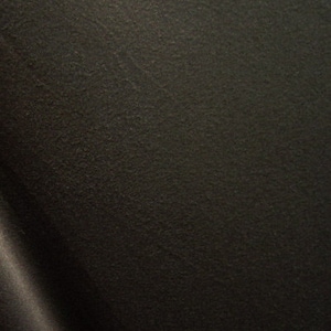 May include: Close-up of a dark brown, textured fabric. The material has a slightly rough surface with subtle variations in tone, creating a rich, solid colour. The fabric appears to be a heavy weight material.