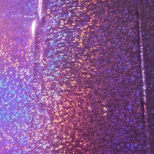 Puede incluir: Primer plano de una tela iridiscente con un esquema de color morado, azul y rosa. La tela tiene una superficie texturizada y brillante.