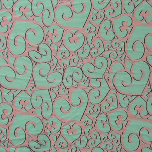 Op de afbeelding: Een naadloos patroon van roze harten met zwarte contouren op een turquoise achtergrond. De harten overlappen elkaar en creëren een wervelend effect.