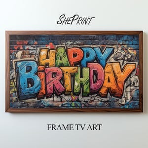 Może przedstawiać: Oprawione dzieło sztuki z napisem "HAPPY BIRTHDAY" w stylu graffiti w żywych kolorach. Litery są obrysowane na czarno i wypełnione odcieniami niebieskiego, pomarańczowego, żółtego i różowego. Tło stanowi ceglana ściana z dodatkowymi graffiti. Widoczne są również teksty "SHEPRINT" i "FRAME TV ART".