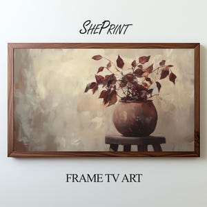 May include: A framed painting of a terracotta pot with a leafy plant in it. The pot is sitting on a wooden stool. The background is a light brown color.