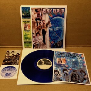 May include: A blue vinyl record with a Pink Floyd album cover, featuring a blue-toned illustration of a person's face. The album cover also includes images of the band members and text that reads "Pink Floyd Live in Sweden 1967".