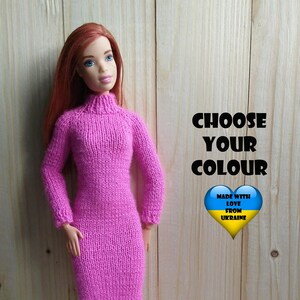 Könnte beinhalten: Ein pinkfarbenes Strickkleid für eine Puppe, hergestellt mit Liebe aus der Ukraine. Das Kleid ist langärmelig und hat einen Rollkragen. Die Puppe trägt weiße Turnschuhe. Wählen Sie Ihre Farbe.