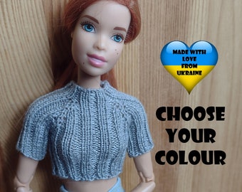 May include: A gray knitted crop top with short sleeves for a doll. The doll is wearing blue denim shorts and has red hair. The image includes the text "MADE WITH LOVE FROM UKRAINE" and "CHOOSE YOUR COLOUR".