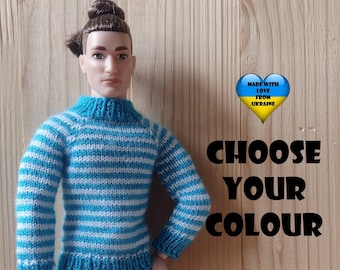 Może przedstawiać: Sweter z dzianiny w niebiesko-białe paski dla lalki. Sweter ma golf i długie rękawy. Tekst "MADE WITH LOVE FROM UKRAINE" znajduje się w kształcie serca z kolorami flagi ukraińskiej. Tekst "CHOOSE YOUR COLOUR" jest w czarnych literach.