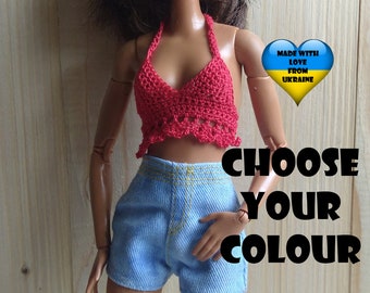 May include: A doll wearing a red crocheted halter top and blue denim shorts. The doll has brown hair and brown eyes. The image includes the text "Made with love from Ukraine" with a heart and the Ukrainian flag.